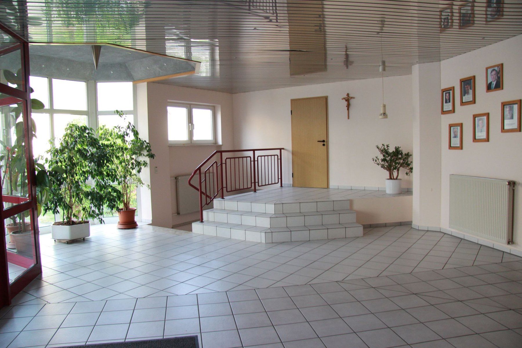 Helles Foyer des Gemeindehauses mit Eingangsbereich und Sitzstufen