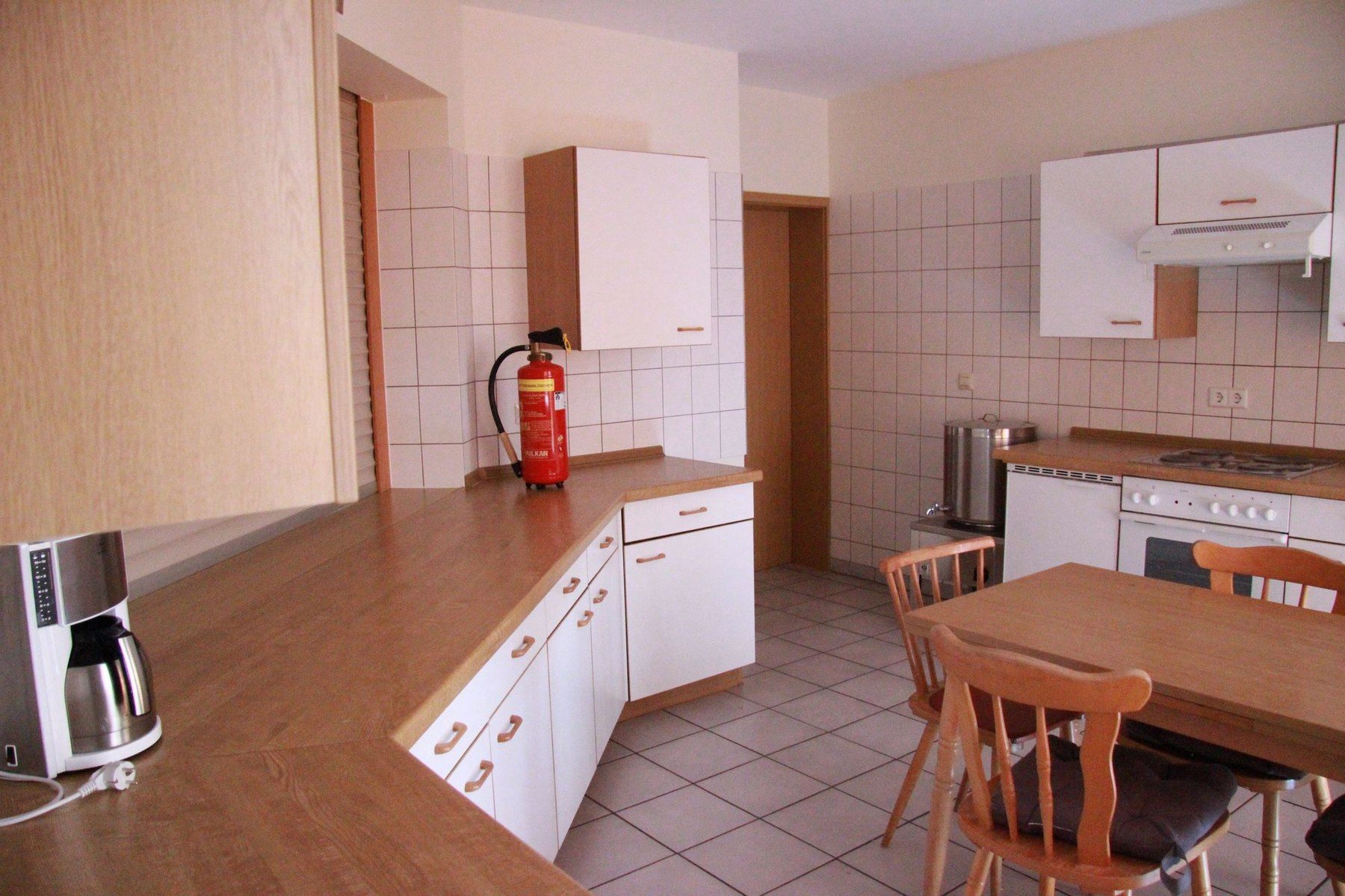 Küche des Gemeindehauses mit Arbeitsflächen und Sitzbereich